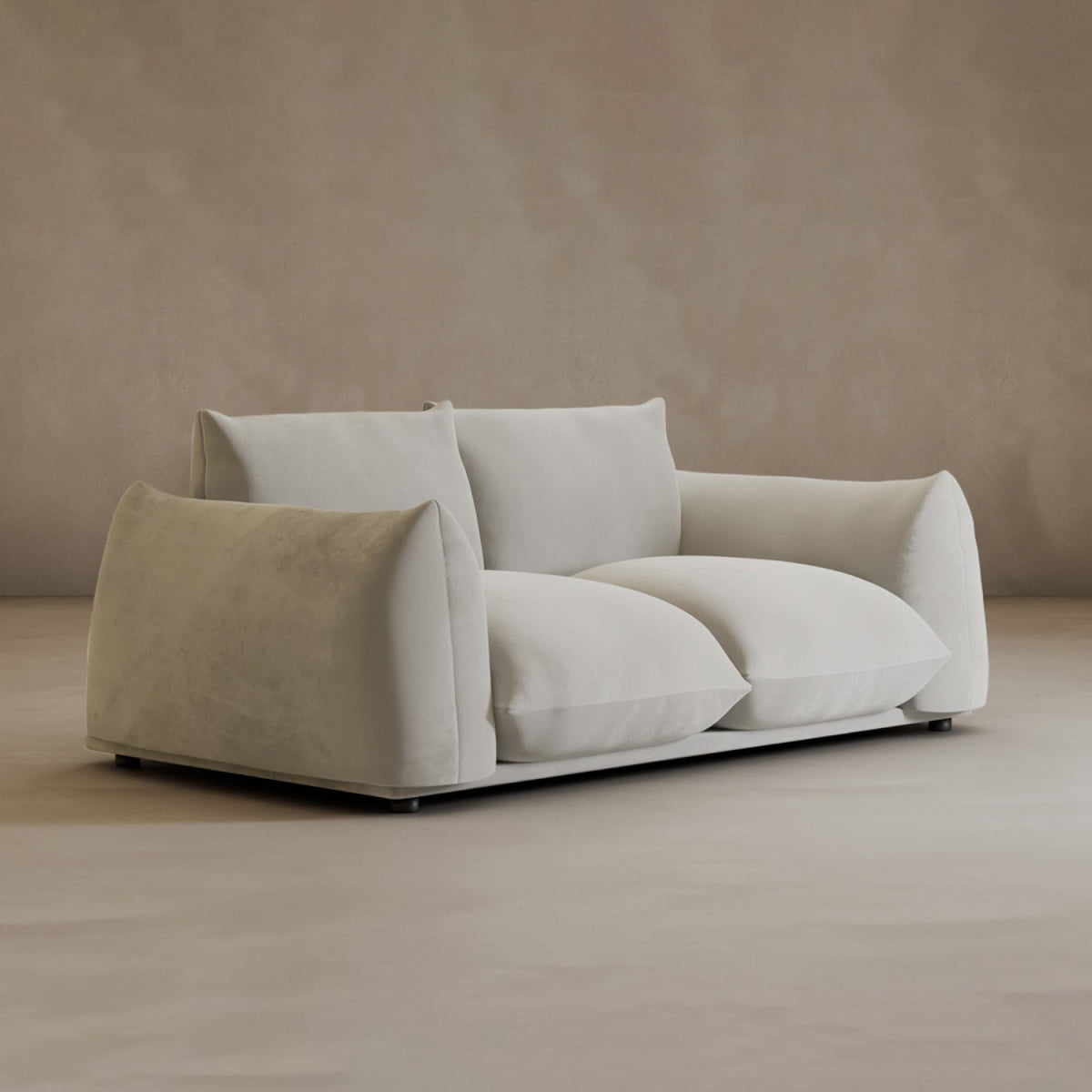 The Calypso Loveseat, with deep, overstuffed cushions and wide armrests, offers modern comfort and elegance as it sits on a light floor against a neutral beige wall.