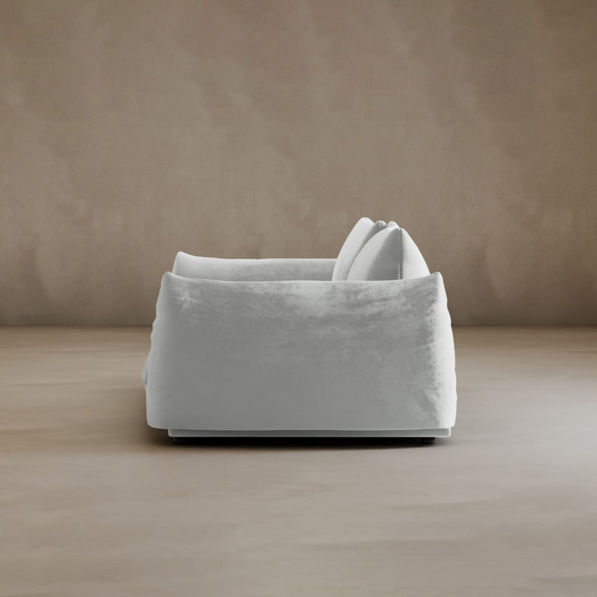 The Calypso Loveseat, a modern plush white piece with two cushions, is featured from the side, exuding contemporary elegance against a plain taupe-brown background.
