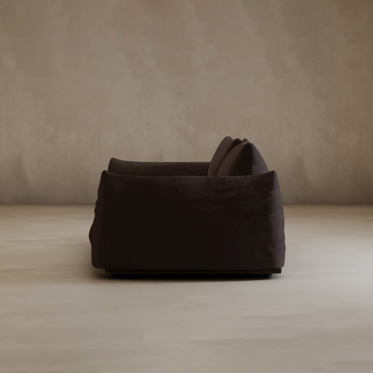 Side view of the Calypso Loveseat, a modern 2-seater in dark brown plush with two cushions, placed on a light floor by a beige wall. The minimal setting highlights its sophisticated, neutral elegance.