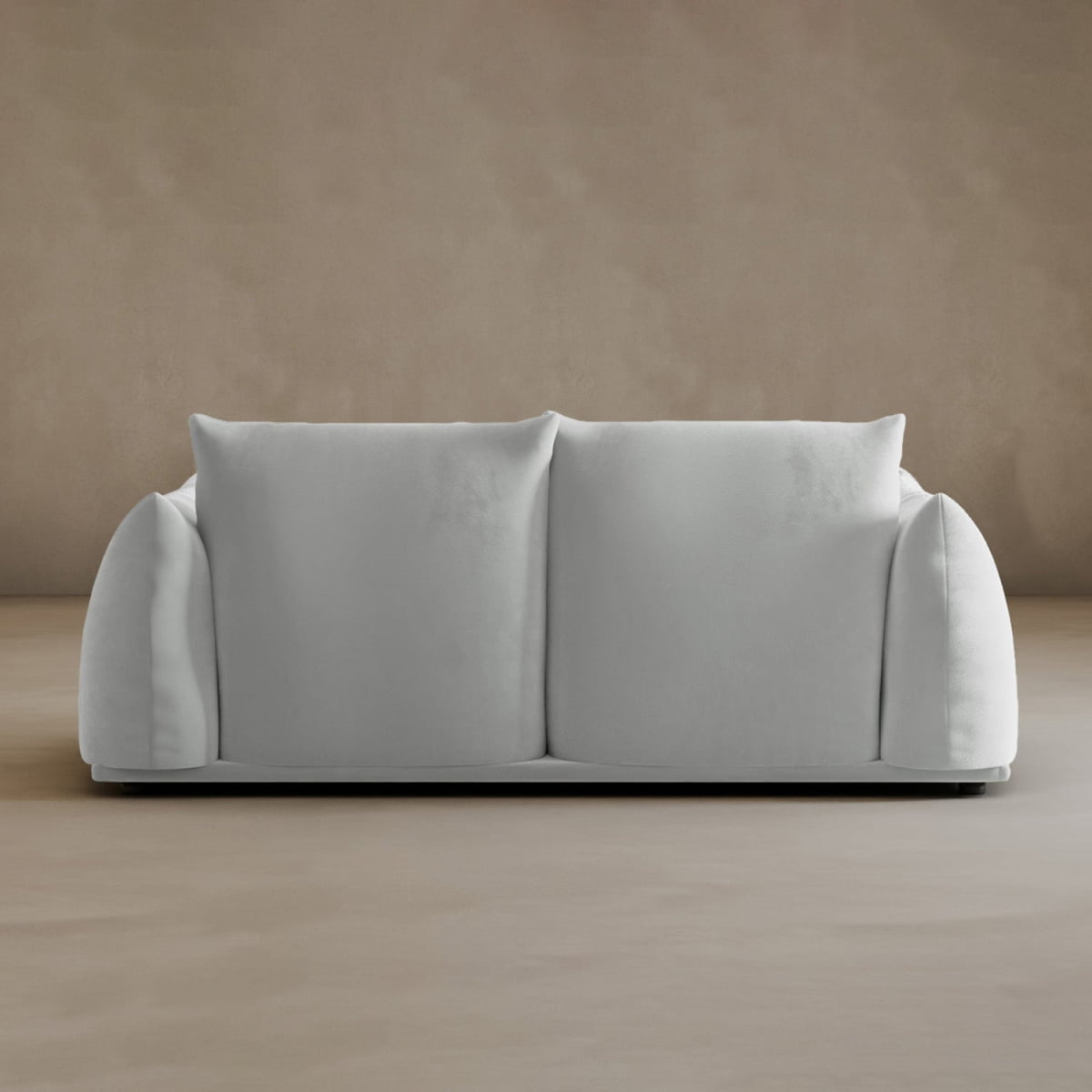 The Calypso Loveseat, featuring plush cushions and rounded arms in a sleek white design, adds modern elegance to any space when placed against a plain beige wall and floor.