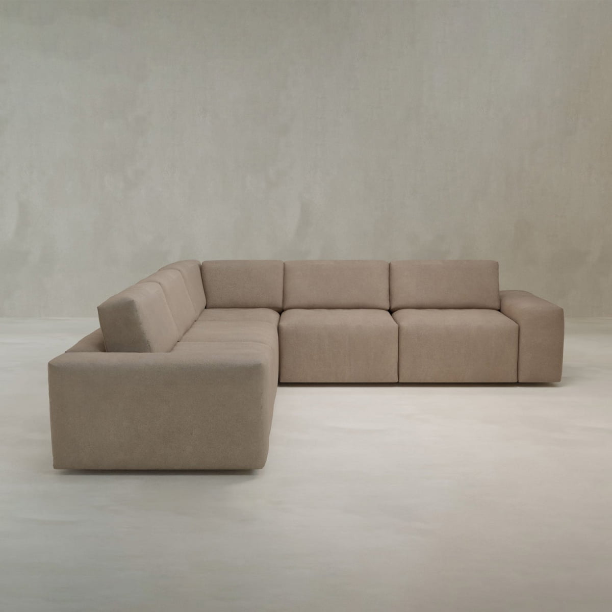 The Canonbury L Shape Sofa features a modern, minimalist design with clean lines and soft, high-performance fabric upholstery, bringing contemporary comfort to any neutral, light-colored space.