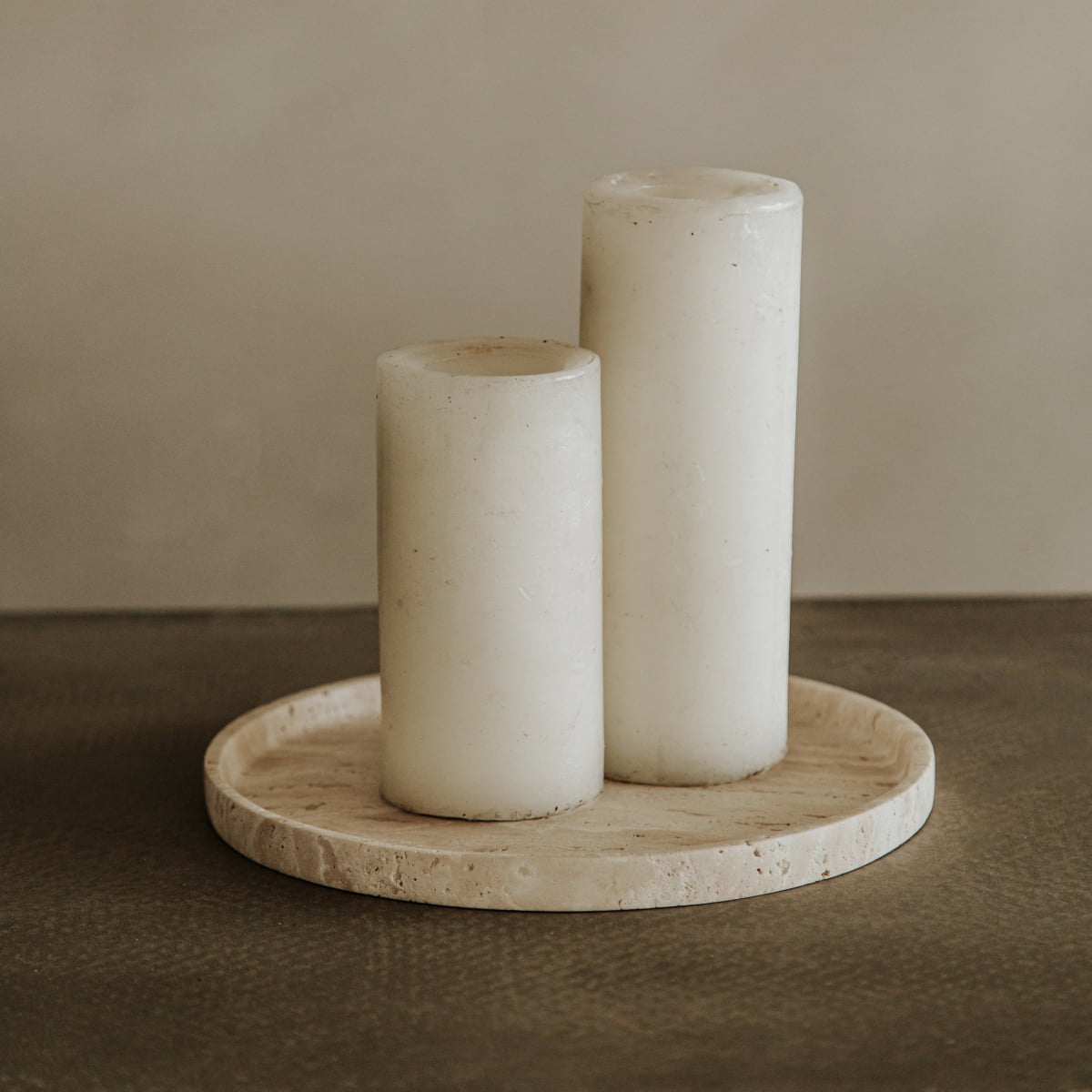 Two white pillar candles of varying heights rest on the Cascade Tray in Large, set against a neutral, minimalist backdrop—an effortless display of natural elegance.