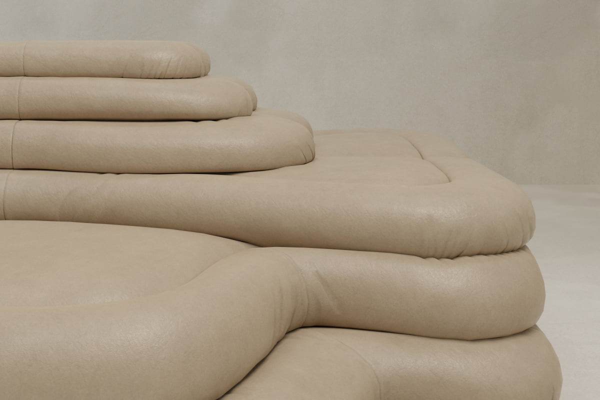 A close-up of the Cascata 2 Piece Sofa, a modern beige leather sectional with a plush, luxurious design set against a light neutral wall.