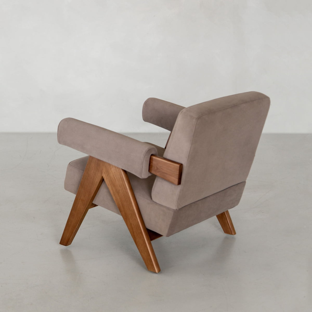 The Chelsea Lounge Chair features light brown faux mohair upholstery and wooden legs and armrests. Set against a plain light gray background, it is angled slightly away to showcase its modern mid-century style.