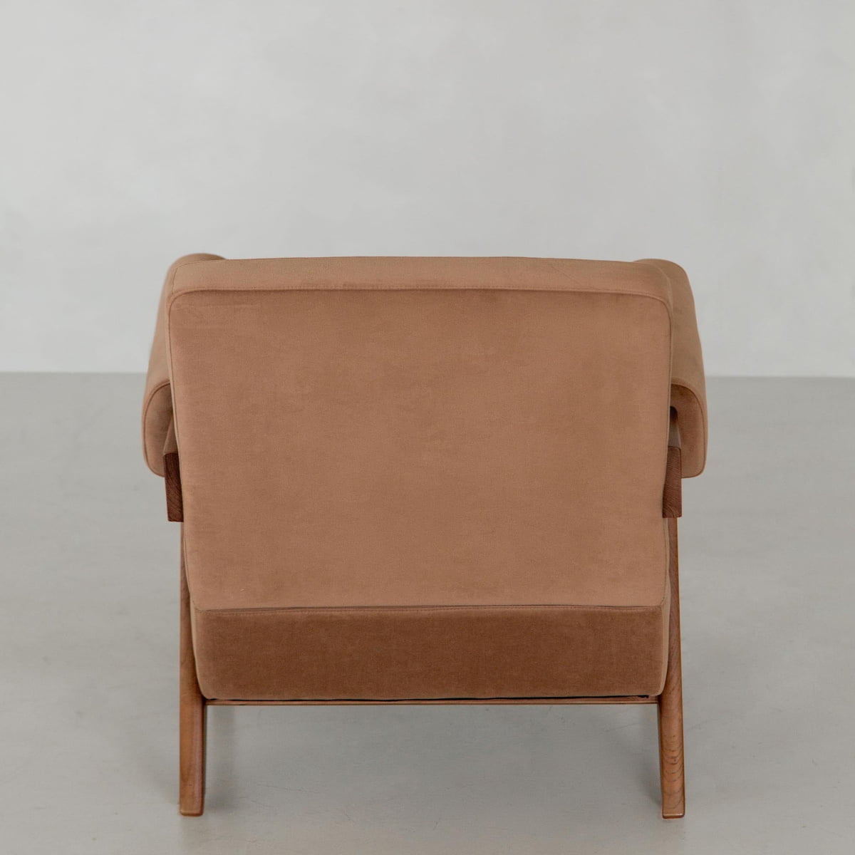The Chelsea Lounge Chair features tan faux mohair upholstery and wooden legs, shown from the back against a light gray background for a refined, modern mid-century look.