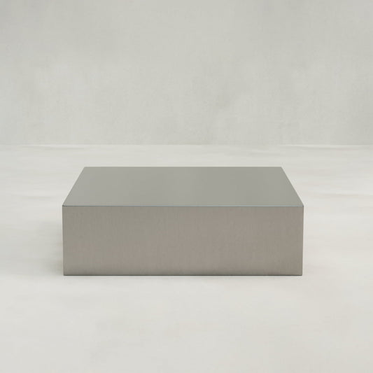 The Forge Steel Large Square Plinth, featuring a smooth, rectangular metallic design with industrial style, is displayed on a plain, light-colored background.
