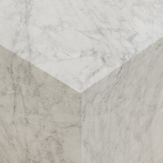 Close-up view of the Griselle Marble Plinth - Cube, crafted in creamy stone with light gray veining, smooth surfaces, and sharp edges that create a refined minimalist silhouette.
