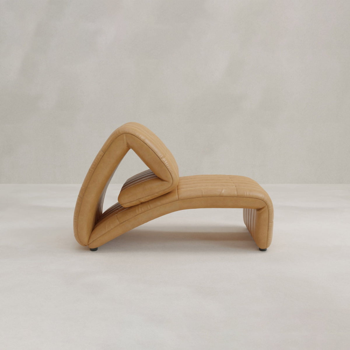 The Hillier Chair features a modern, sculptural shape in premium vintage tan leather with unique curved and geometric design, displayed on a light neutral background.