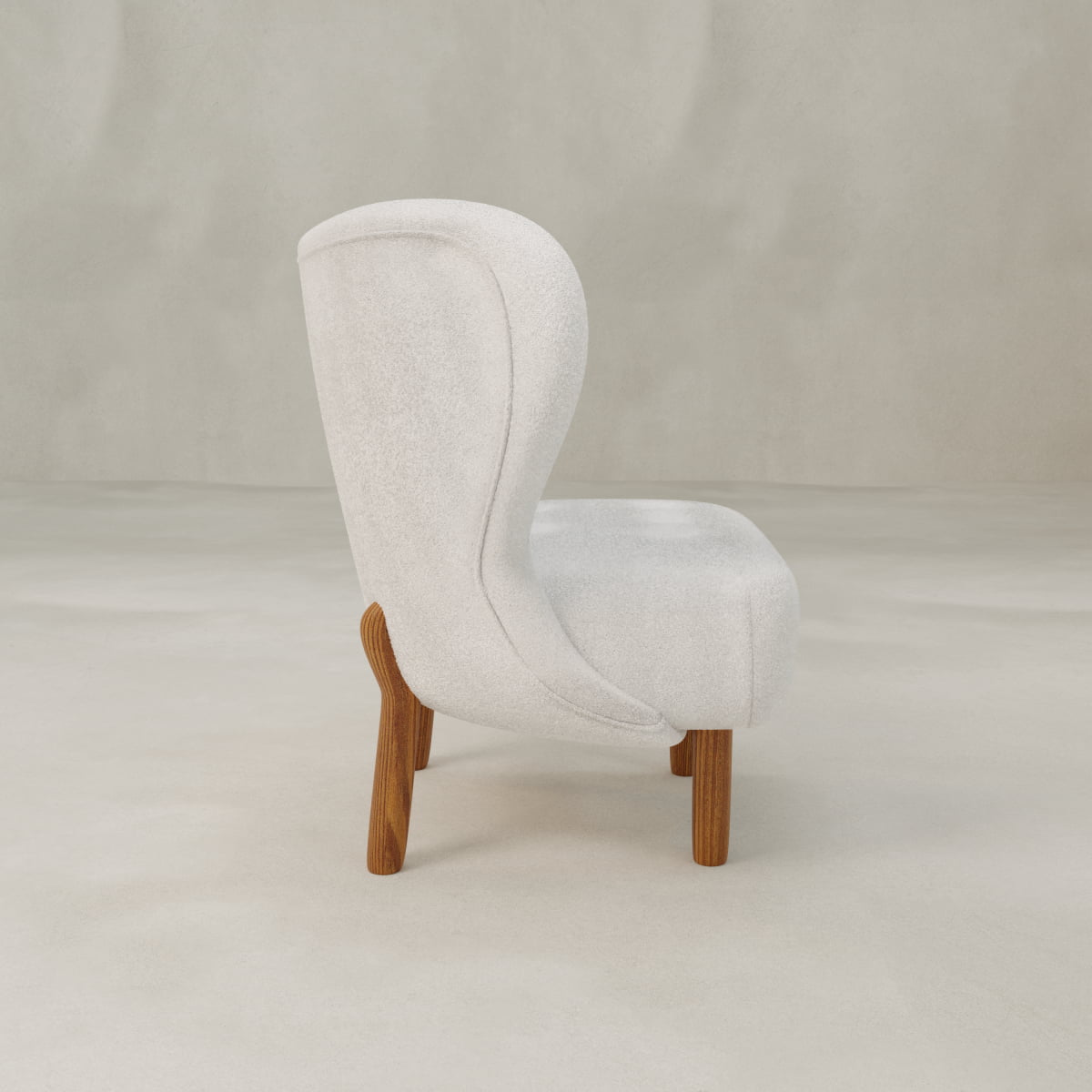 The Hornsey Chair, a modern compact accent piece with a curved white upholstered back and seat and wooden legs, is shown in profile against a light neutral background.