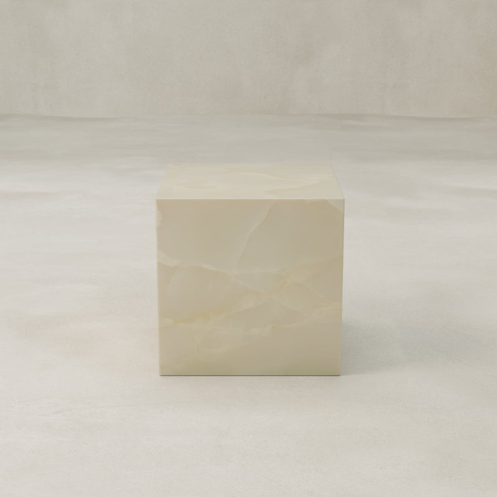 The Lunelle Onyx Plinth - Cube features a minimalist, semi-translucent ivory design with subtle marbling, serving as an elegant sculptural centerpiece against any neutral background.