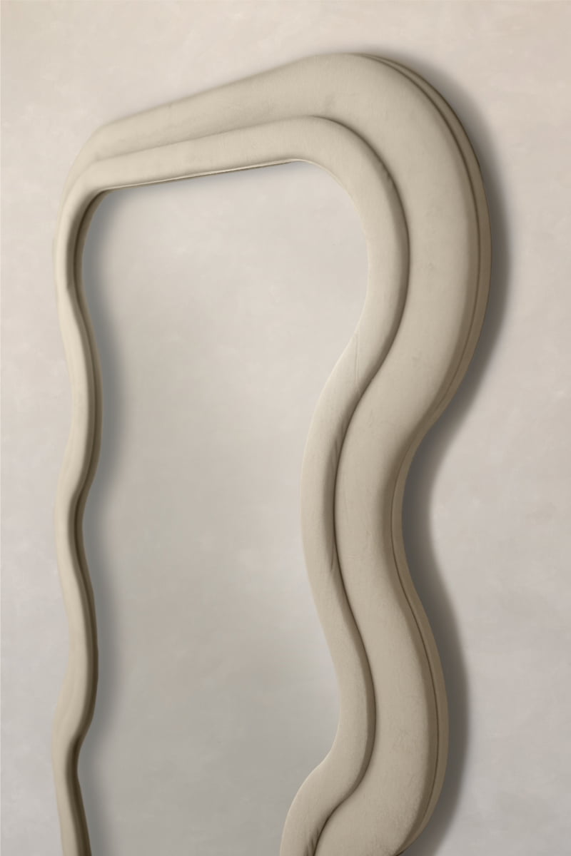 The Onde Mirror Large with its wavy velvet frame hangs on a light wall, adding contemporary sophistication and giving the space a modern, artistic touch.