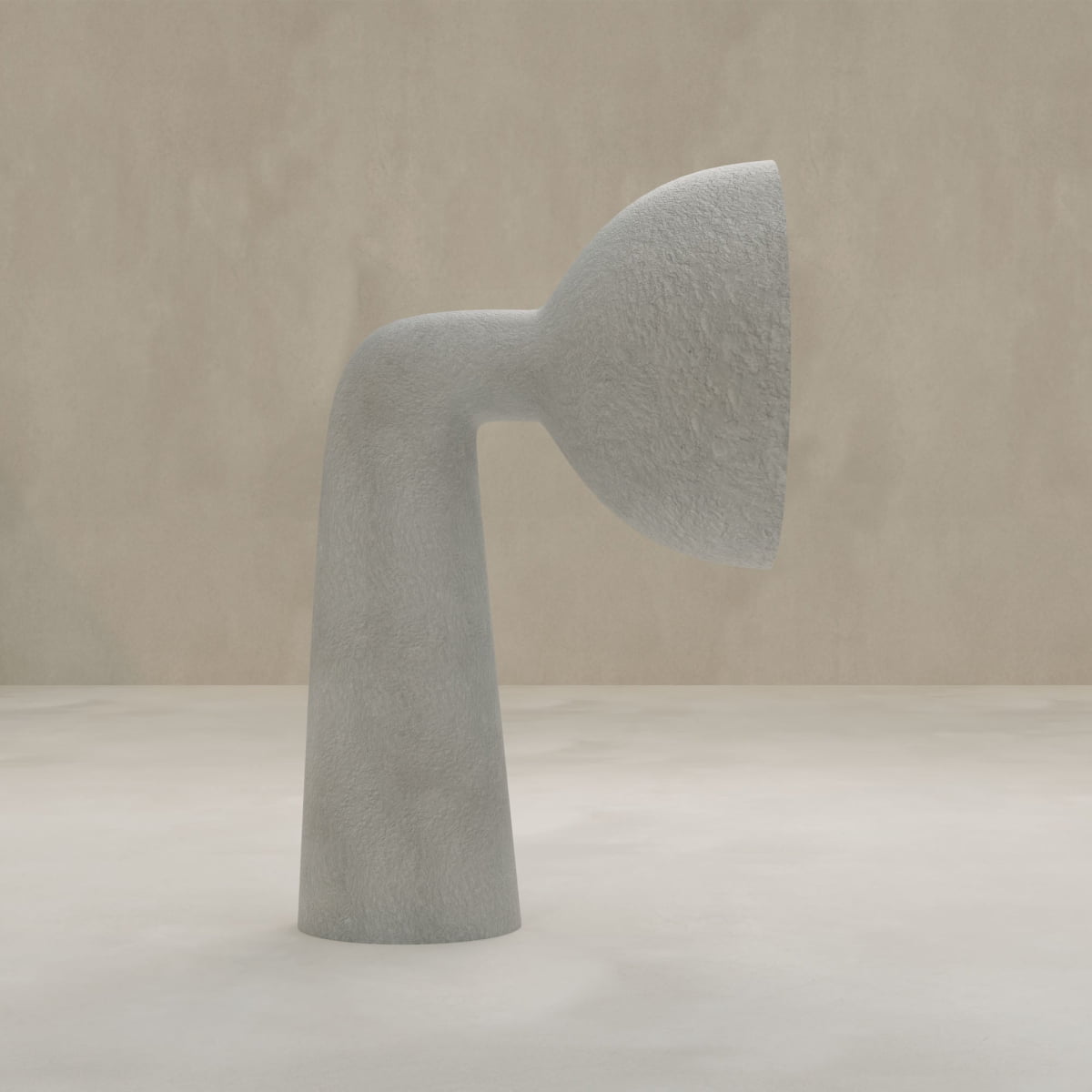 The Orbis Medium Floor Lamp features minimalist design with a textured gray finish, a curved tubular base, and a wide shallow top, showcasing sculptural artistry against a plain beige background.