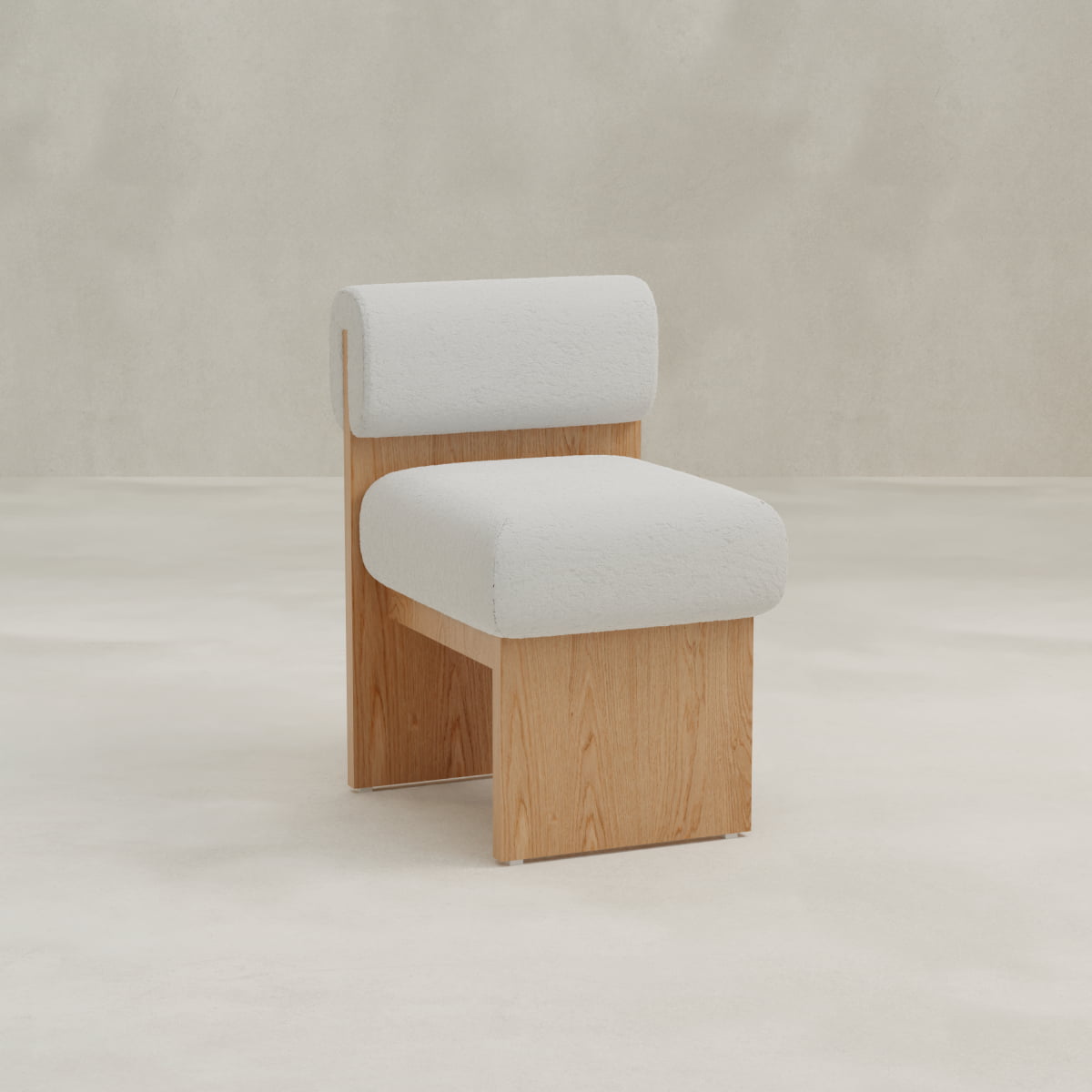 The Primrose Chair features a light wood base and legs, a thick cushioned seat, and a rounded backrest upholstered in soft bouclé. Its minimalist design has clean lines and provides subtle ergonomic support.