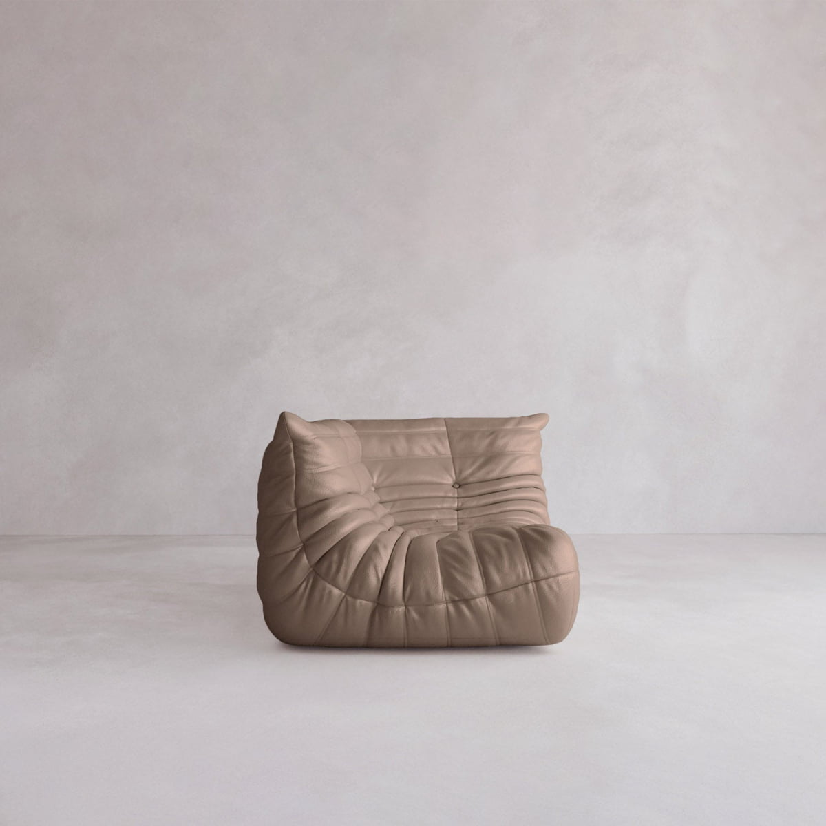 The Rolo Lounge Corner Sofa, an armless brown tufted piece with a soft, cushioned look, sits on a light floor against a pale background, showcasing subtle 70s-inspired lounge chair vibes.