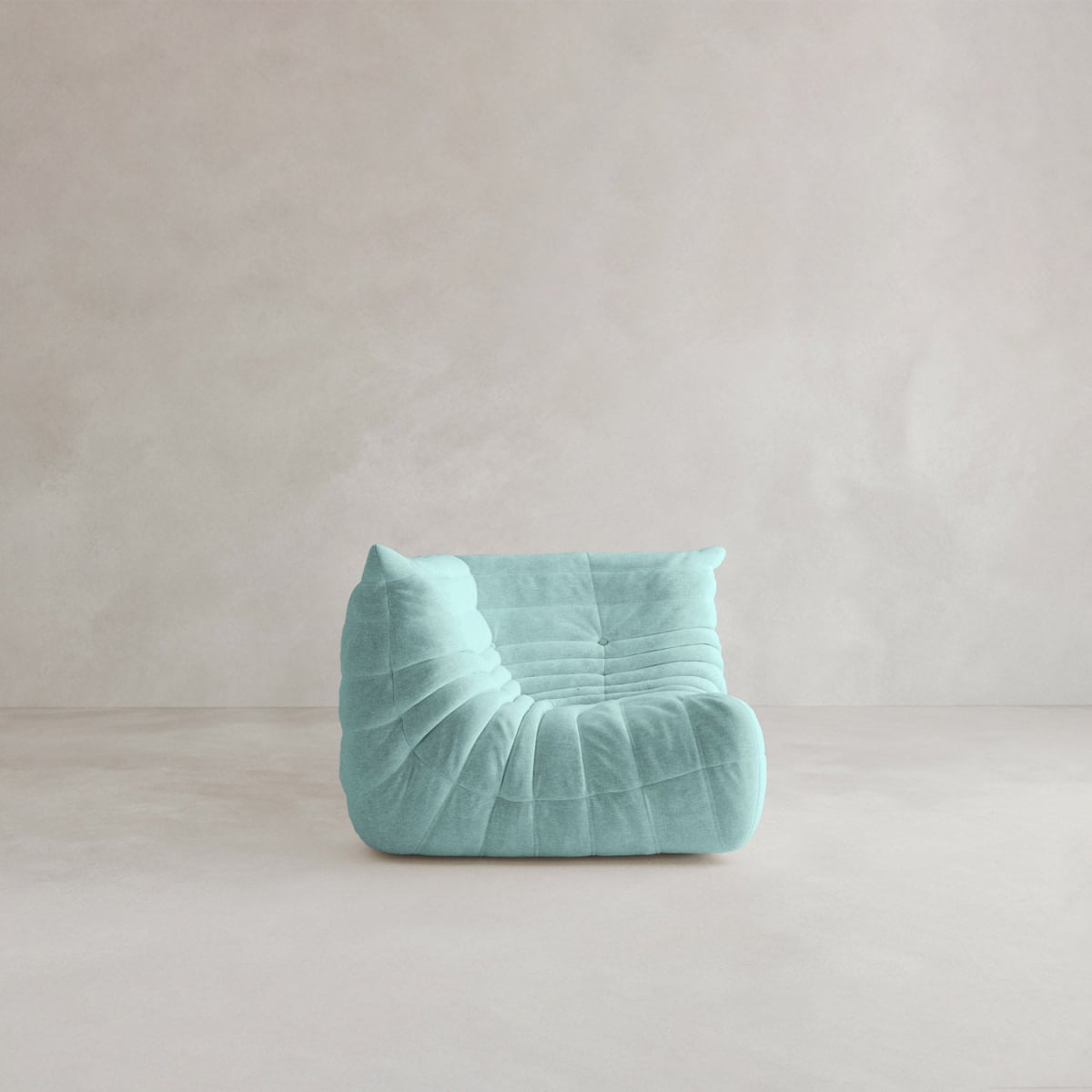 The Rolo Lounge Corner Sofa, a modern light blue armless piece with plush tufted upholstery and mid-century style, sits on a smooth neutral floor against a plain textured beige wall.