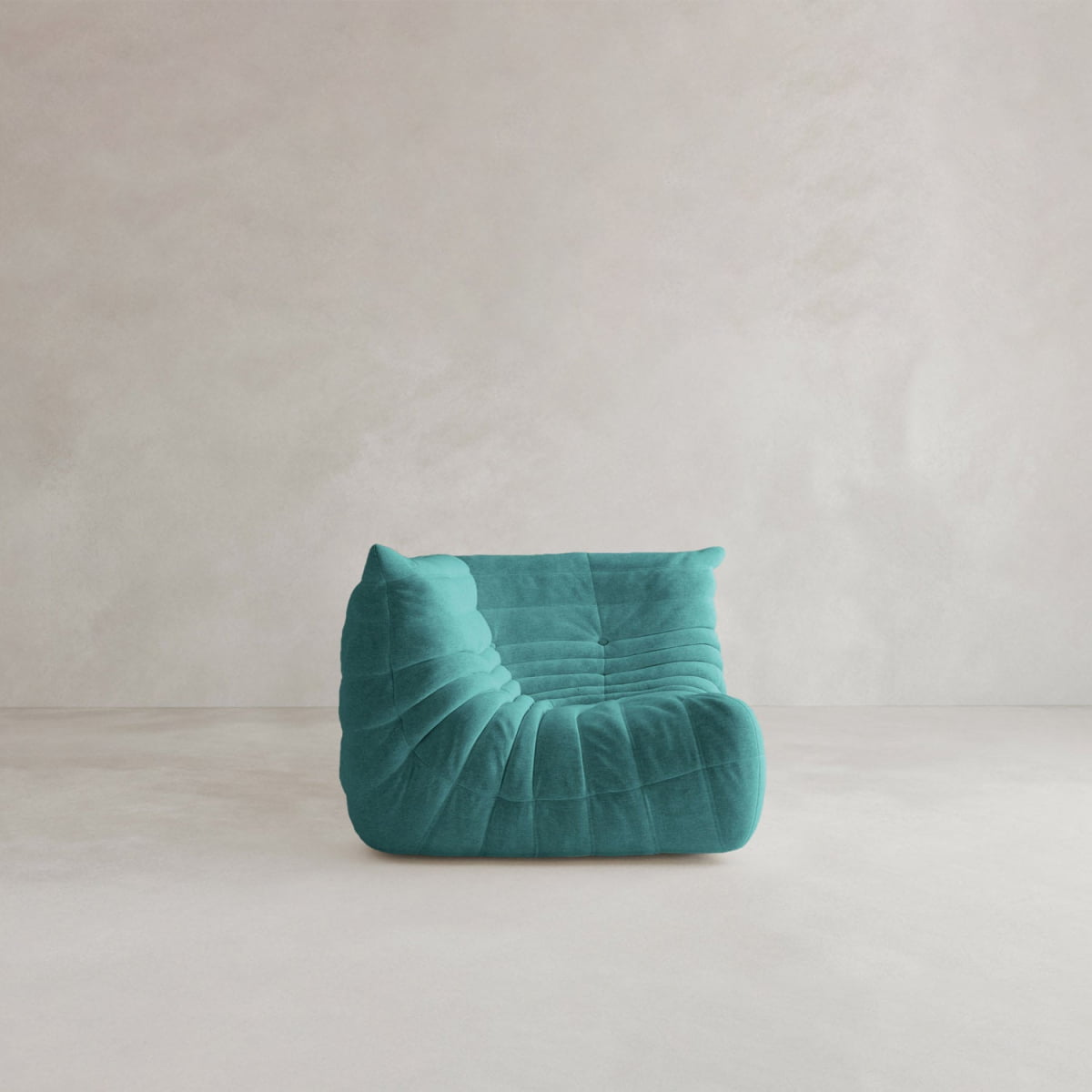 The Rolo Lounge Corner Sofa, a modern armless piece in turquoise with plush pleated 70s-inspired design, sits on a light textured floor against a neutral beige wall.