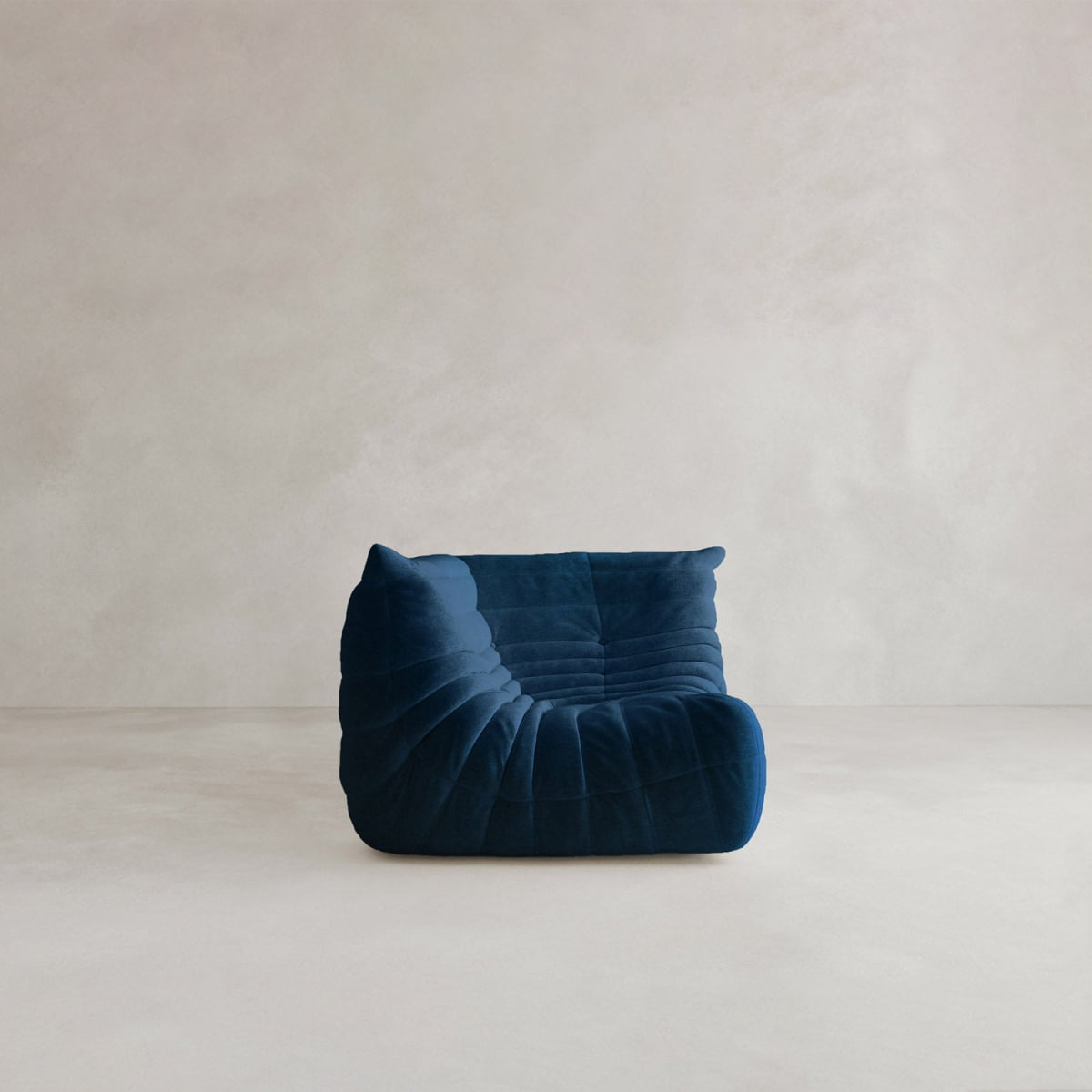 The Rolo Lounge Corner Sofa, with its modern armless design, deep blue velvet upholstery, and low profile, adds mid-century flair to a light minimalist space.
