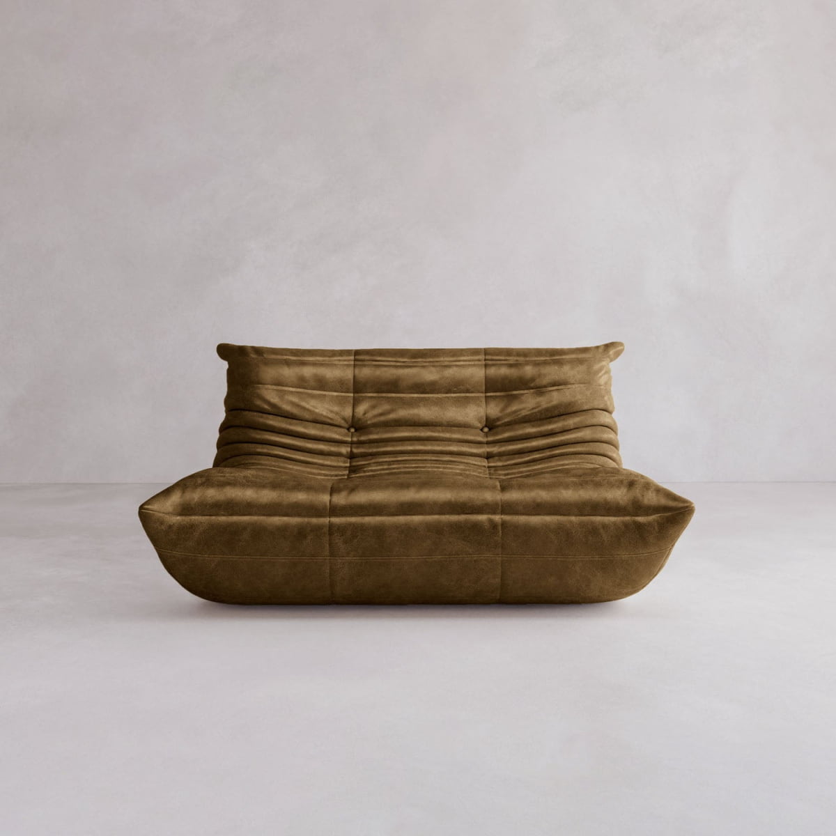 The Rolo Lounge Loveseat features modern brown suede, gathered ruched upholstery, a low armless profile, and subtle mid-century influences, all set against a plain light gray background.