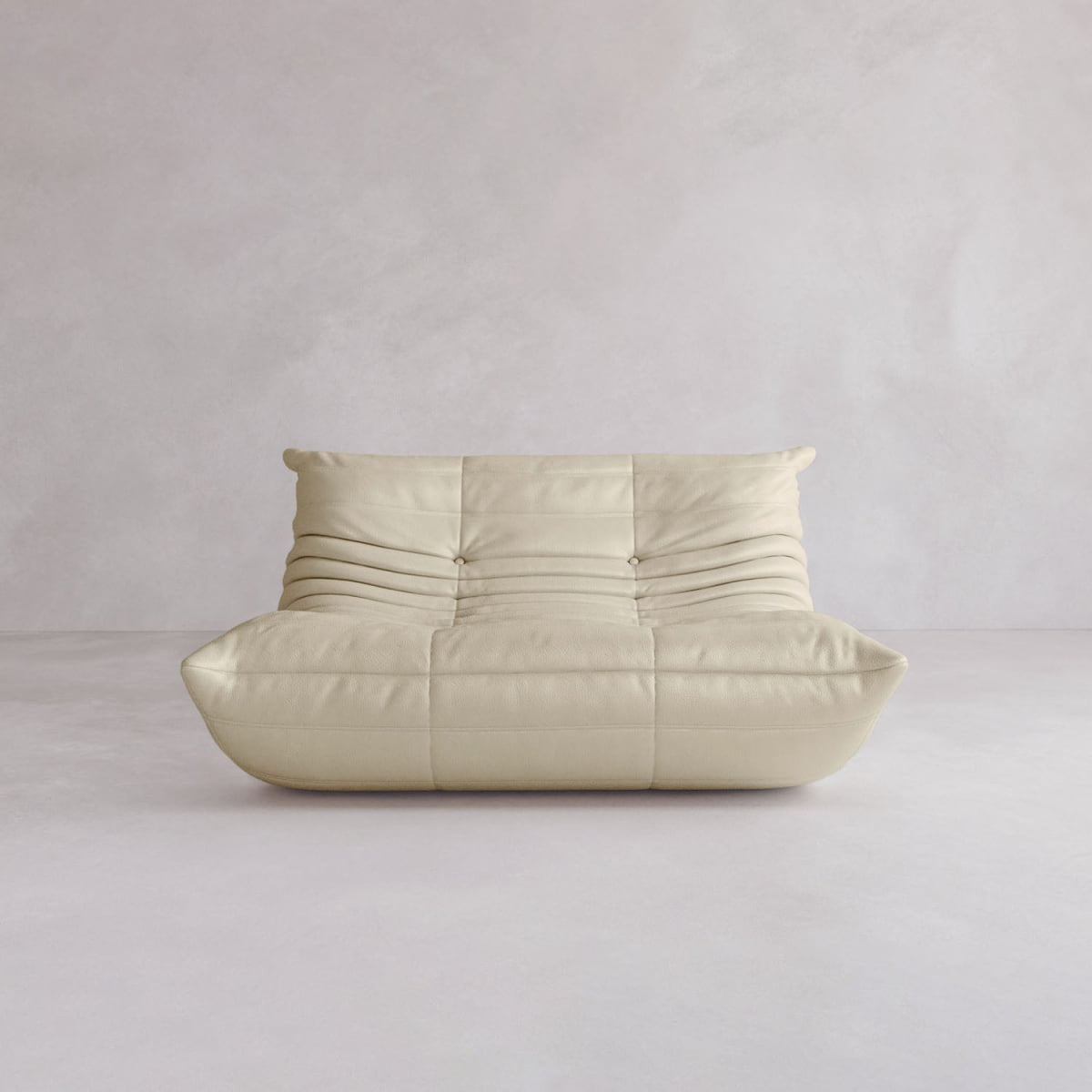 The Rolo Lounge Loveseat features a modern, low-profile design in beige with soft, tufted cushions and a quilted look, evoking mid-century style for timeless appeal against any light-colored wall or floor.