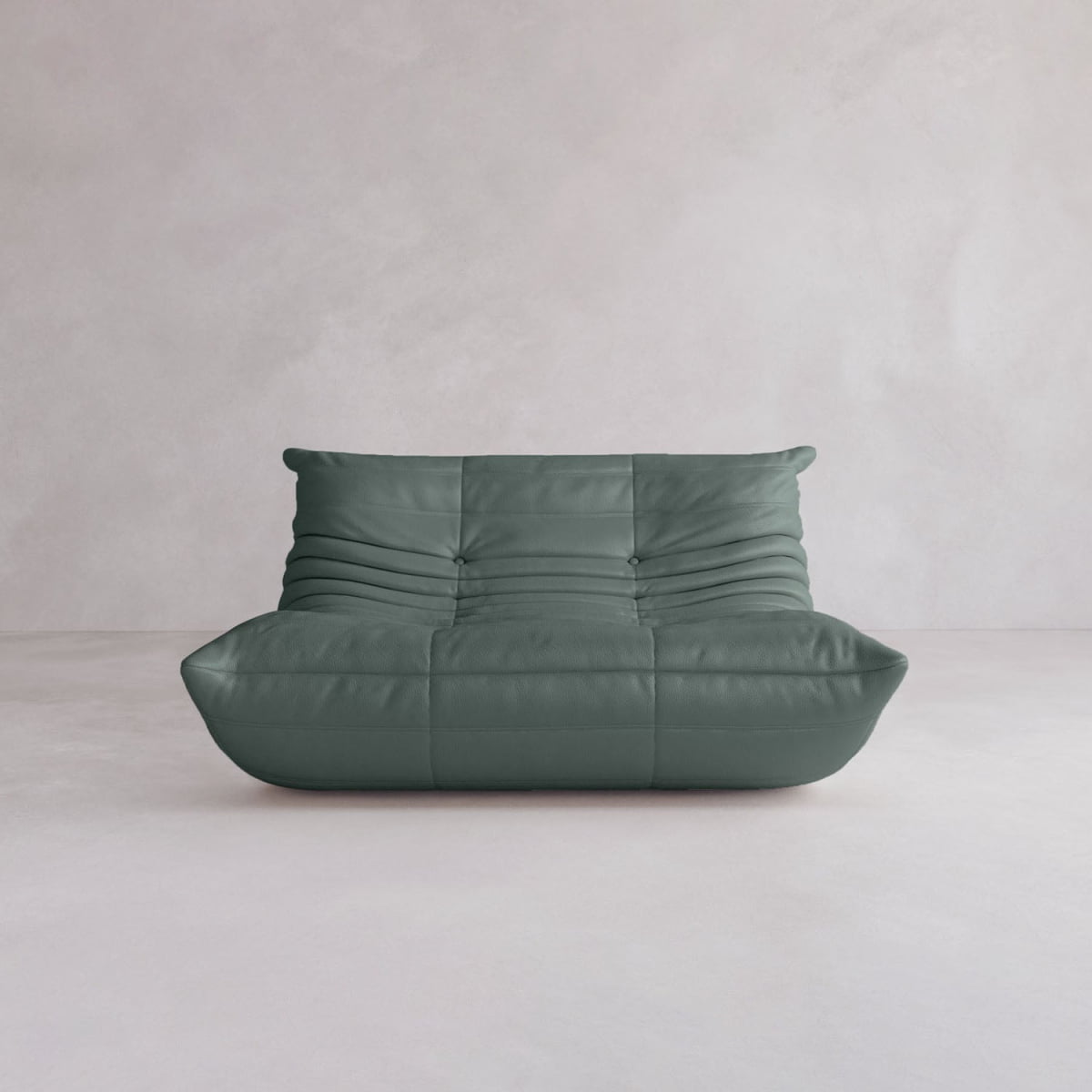 The Rolo Lounge Loveseat is a modern, low-profile sofa in dark green with soft, plush upholstery and horizontal tufting, featuring mid-century style against a minimalist light grey wall and floor.
