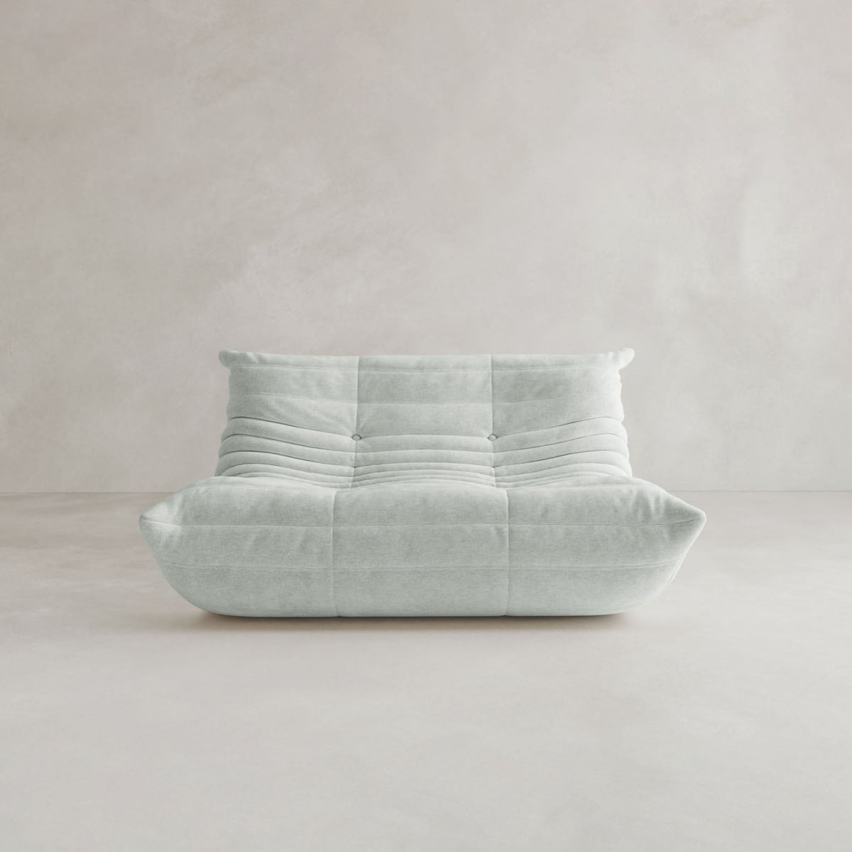 The Rolo Lounge Loveseat, a modern armless design in light gray with soft tufting and mid-century accents, sits in a minimalist room with pale matching walls and floors.