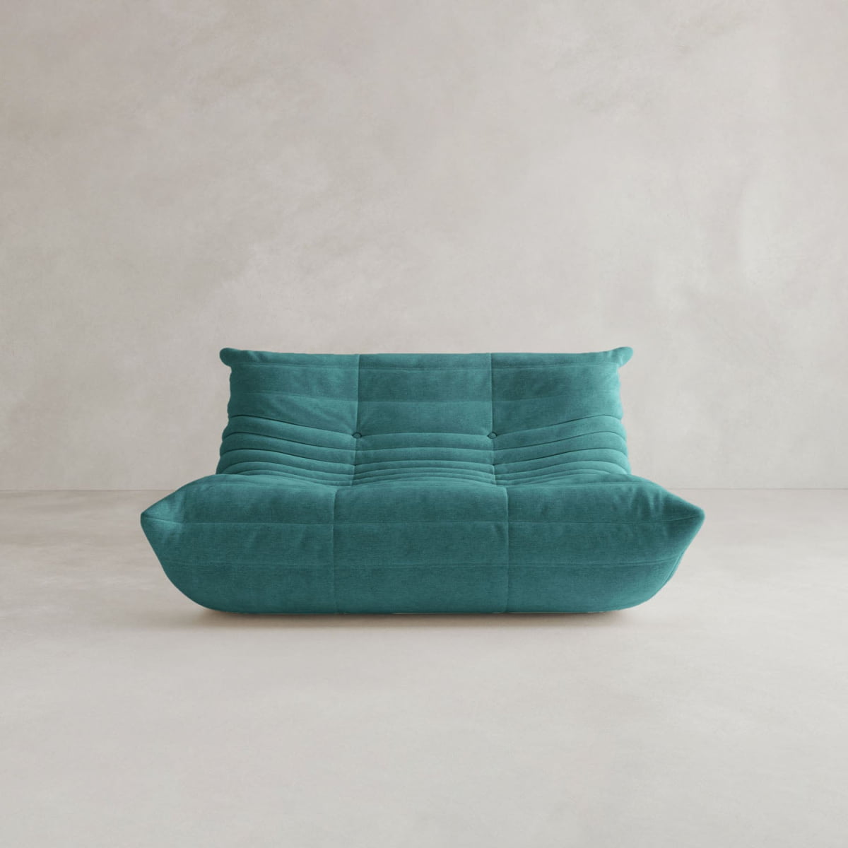 The Rolo Lounge Loveseat features deep horizontal tufting and soft, rounded edges in modern teal, evoking mid-century style. It’s shown on a light floor with a minimal pale backdrop.