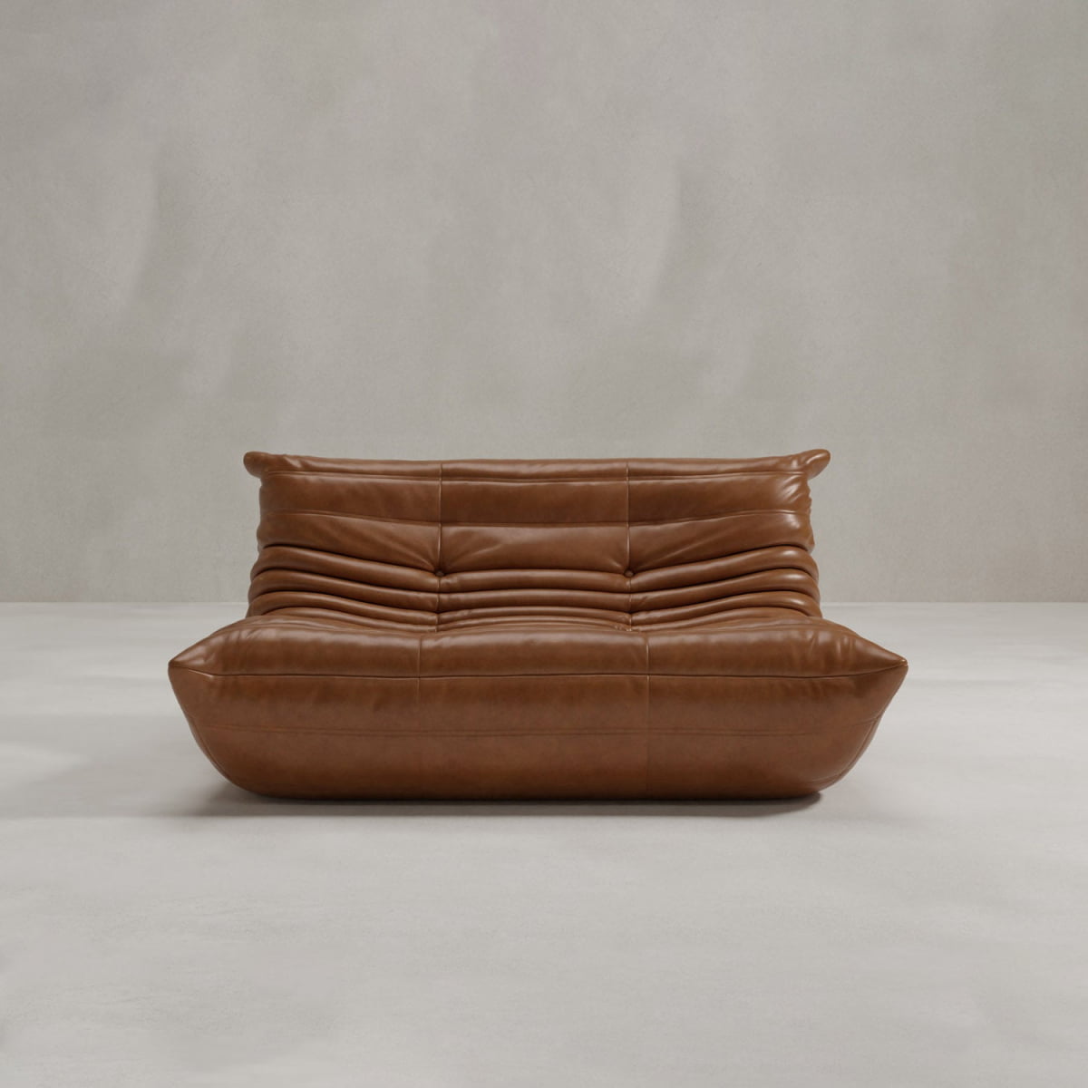 The Rolo Lounge Loveseat features a modern brown leather design with a low, wide profile and horizontal tufting, channeling mid-century style against a plain light gray wall and floor.