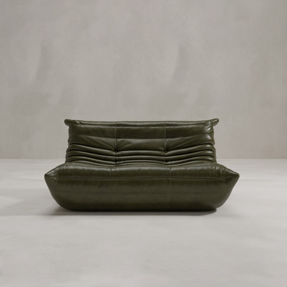 The Rolo Lounge Loveseat, a modern dark green leather sofa with a low, wide seat and tufted, ruched backrest, showcases mid-century design on a light gray floor against a plain light gray wall.