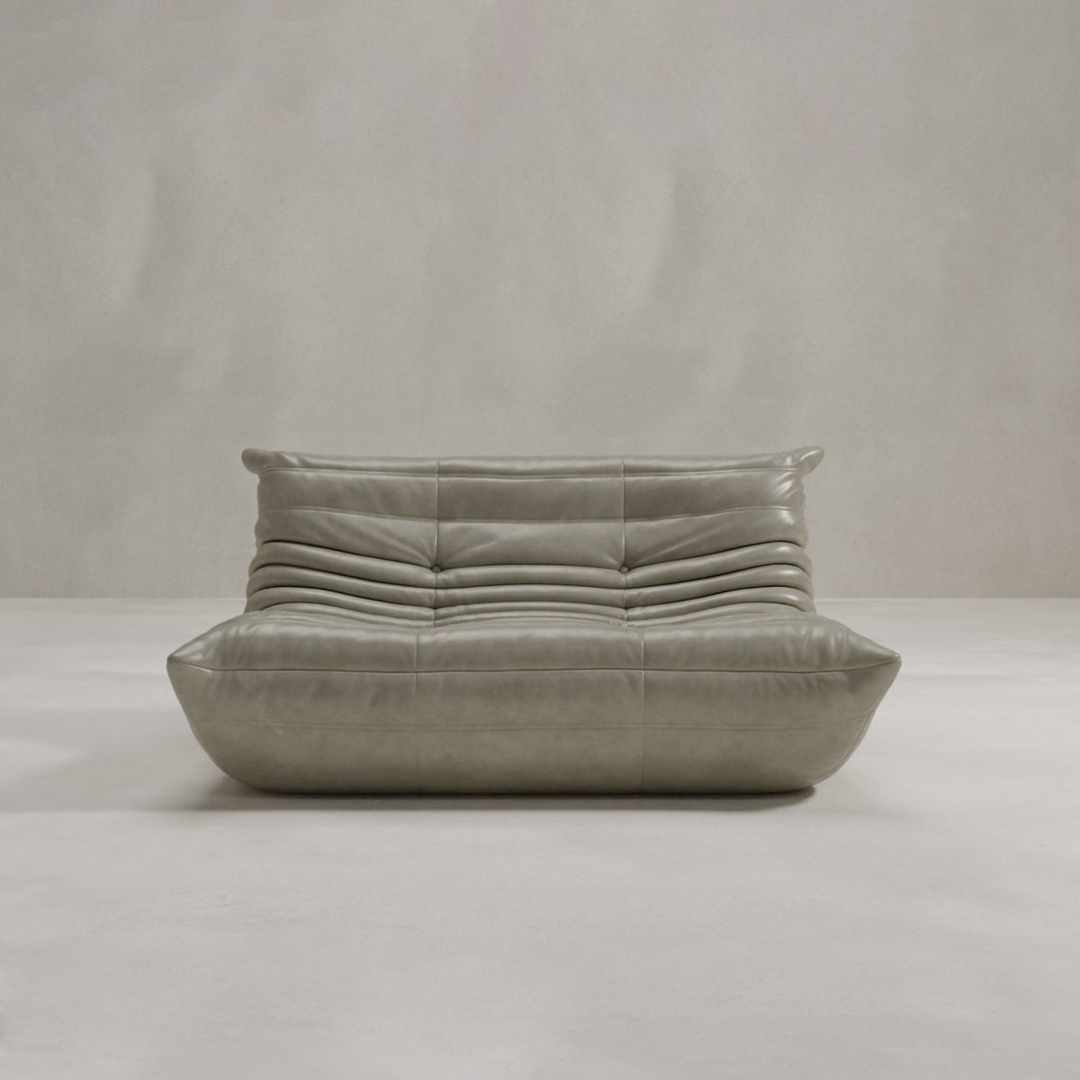The Rolo Lounge Loveseat is a modern, low-profile taupe leather sofa with plush horizontal tufting and a sleek minimalist design inspired by mid-century style, shown against a plain light gray background.