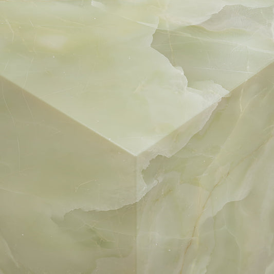 A close-up of the Verdaine Onyx Coffee Table XL in pale green highlights its smooth, polished surfaces, natural translucent veining, sharp sculptural edges, and layered texture for a serene standalone statement.